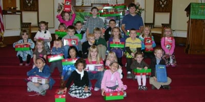Group of children posing for photo holding gifts 